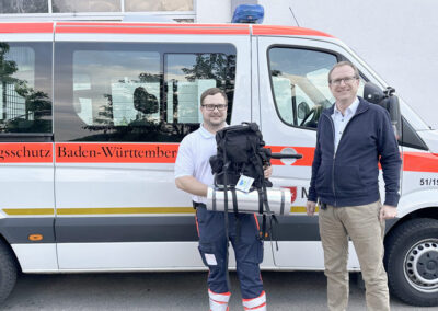 Gewinner Herr Dominik Vetter, links; Herr Bernd Schiele, rechts, beide vor Fahrzeug des Bevölkerungsschutzes Baden Württemberg